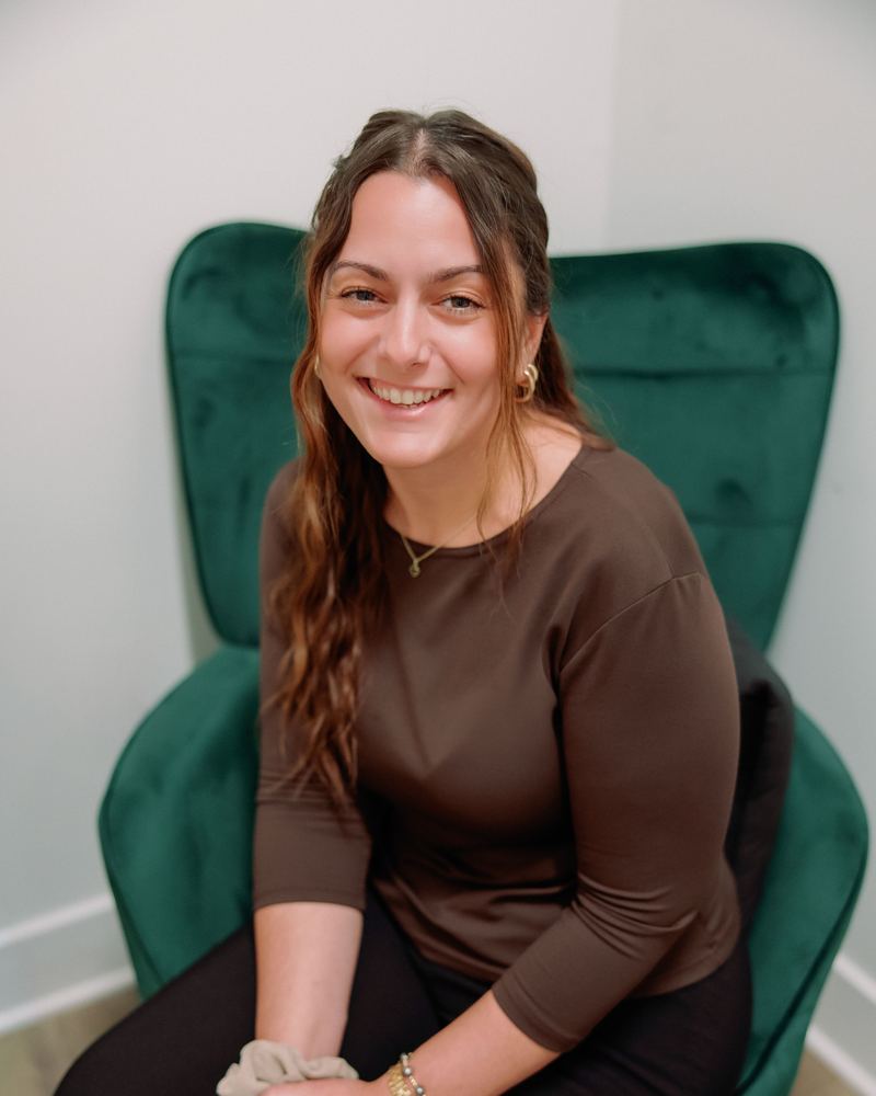 Jennifer Lombardo, LCSW, smiling in a green armchair