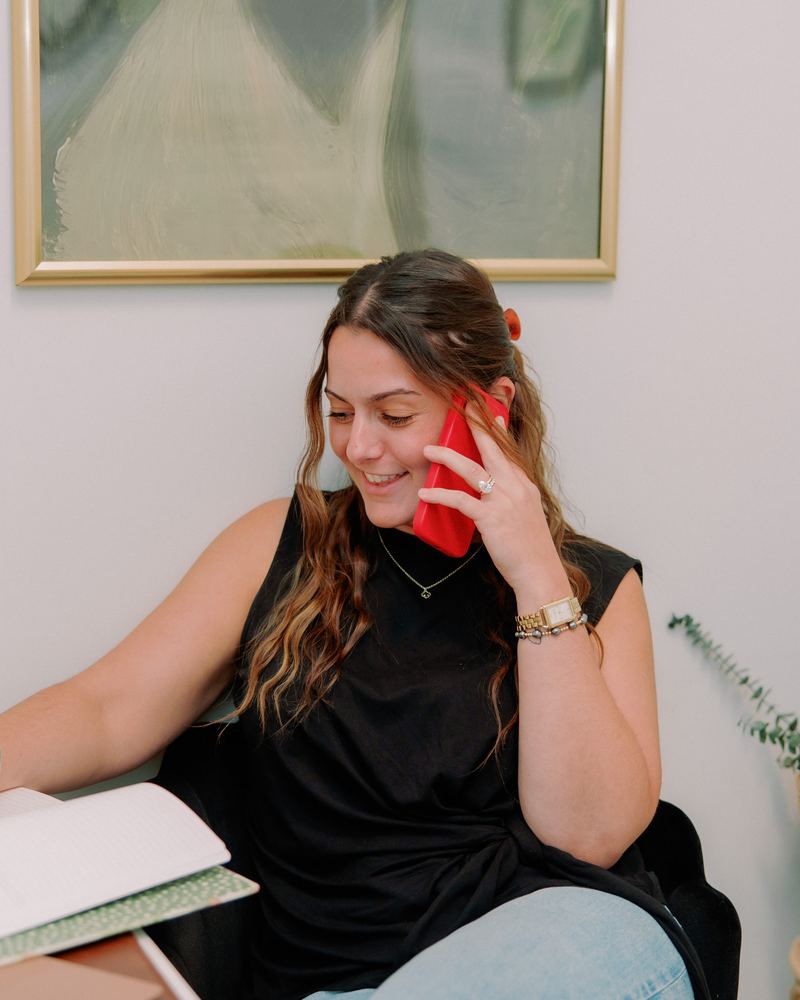 Jennifer Lombardo smiling on a phone call while taking notes